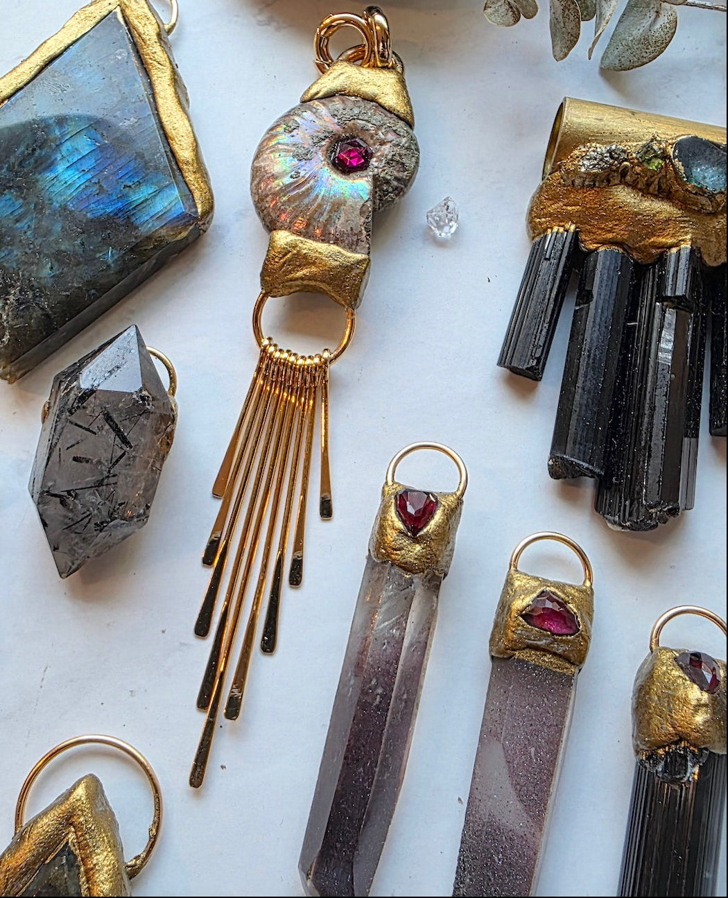 Collection of gold and gemstone jewelry on a white surface