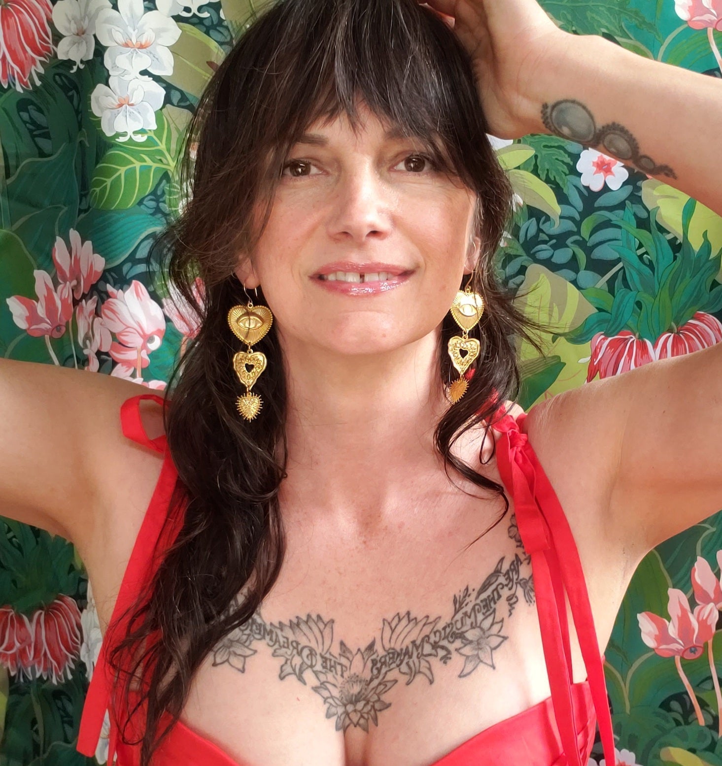 Woman in a red bikini with tattoos against a floral background